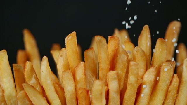 Super Slow Motion Detail Shot of adding Salt on Fresh French Fries at 1000fps.