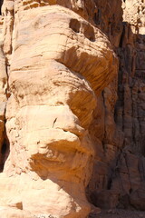 Deserted landscape view of the Wadi Rum desert, close-up of a rock cliff,  mountain and dunes, orange and red, Jordan.