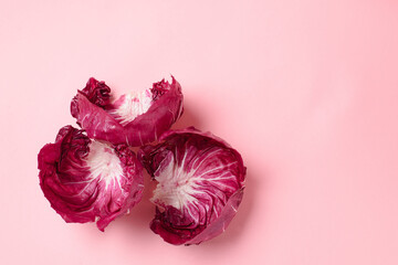 Fresh radicchio lettuce leaves on a pink background. Copy space