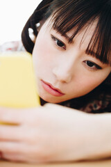 Obraz premium スマホを見て落ち込む女性