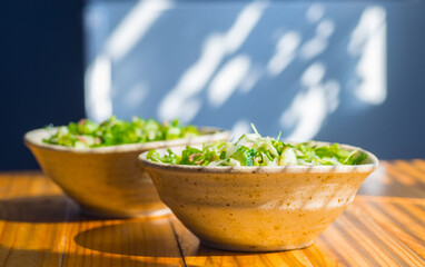 Greens and tuna salad in a ceramic bowl.