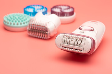 Epiliergerät mit Zubehör Nahaufnahme mit rosa Hintergrund