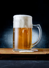 Delicious and refreshing beer mug on a wood table and dark background