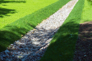 drainage, a drainage system in a Park area, a waterway overgrown with lawn and paved with stones,...