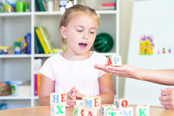 developmental and speech therapy classes with a child-girl. Speech therapy exercises and games with letters. dice game