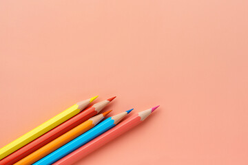 Colorful pencils on pink background