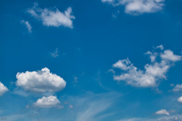 Beautiful blue sky with with light puffy cirrus clouds background