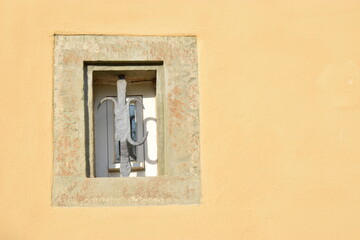 Sandsteinumrandetes Fenster in einer lehmgelben Putzfassade