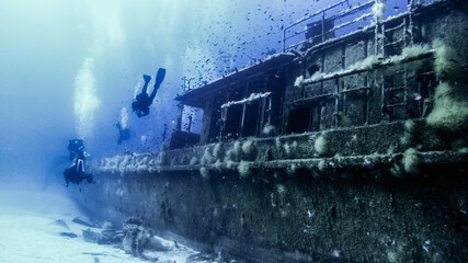 Scubadiving. Scuba divers diving at the shipwreck.