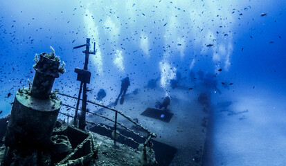 Scubadiving. Scuba divers diving at the shipwreck.