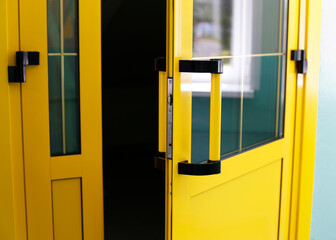The bright yellow glass door is open. Entrance to the premises.