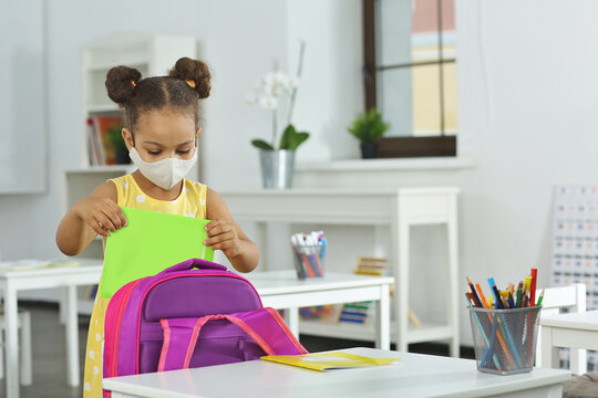 An African-American Girl Takes A Notebook Out Of Her School Bag.