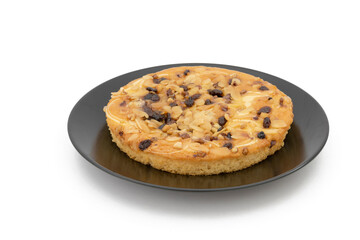 Tarta de pasas y frutos secos sobre fondo blanco.