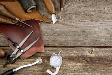Leather craft tools on old wood table. Leather craft workshop.