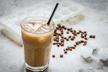 coffee ice cubes and beans with latte on stone desk background