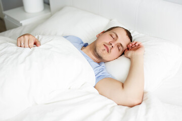 good morning concept - portrait of young man sleeping in bed