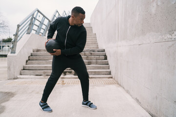 Athletic man doing wall ball exercise.