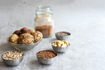 Vegetarian food-energy balls, on a gray background in a Cup, next to Chia seeds, flax, sunflower, peanuts. Nutritious snack. Close-up, selective focus,
