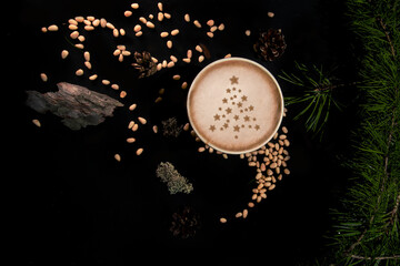 Flat lay with paper cup of coffee on black background with pine tree and cedar seeds