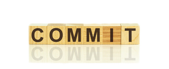 COMMIT word written on wood block, concept commitment