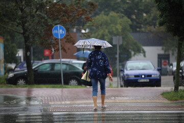 woman with umbrella in rain, street Poland