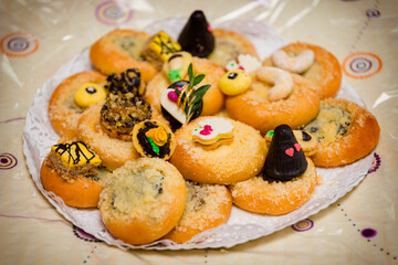 Wedding cookies with cakes on a paper gift mat.