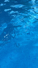 Soft focus background. Swimming pool water texture in abstract style on blue background. Ripple water. Swimming pool water sun reflection background. Summer vacation.