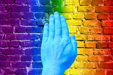 LGBT. Man's hand on a background of a rainbow on the texture.
