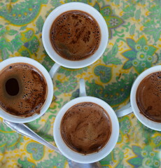 A few cups of coffee on a colorful tray.
