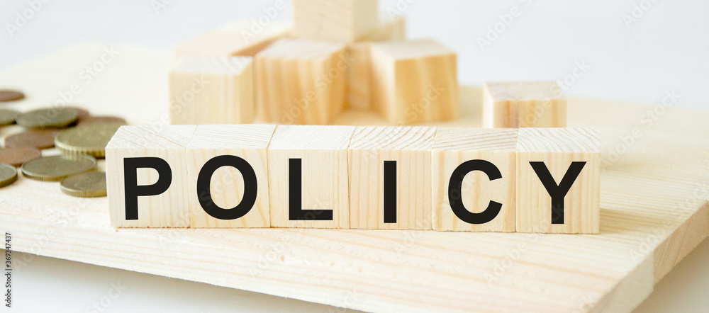 Fototapete the word policy is written on cubes close-up. light background in the background of the coin