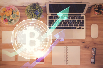 Blockchain theme hologram drawings over computer on the desktop background. Top view. Double...