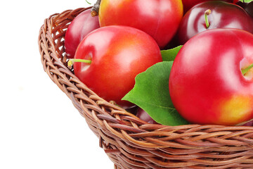 plums in basket isolated on white background