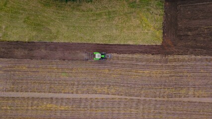 Traktor mit Pflug bricht Acker um, Landwirtschaft aus der Vogelperspektive