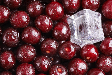 Ripe red cherry with an even surface with an ice cube and water drops. Healthy food freshness, close-up