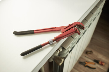 central heating system repairing indoors. water aluminum radiator close up. work tools for maintenance. diy concept