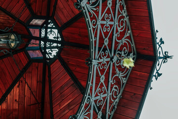 wooden alcove ceiling with forged decorative elements in traditional style