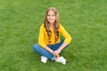 Happy smiling little girl relaxing green grass, summer vacation concept