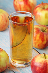 A glass with apple juice and ripe apples	
