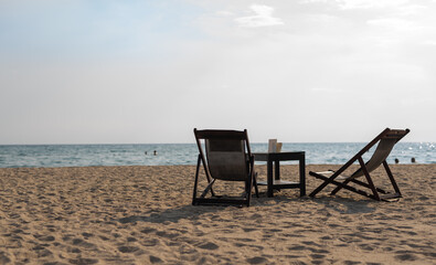 Empty beach lounge chairs in front of the sea, copy space.