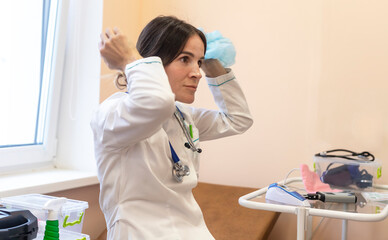 Tired medical assistant doctor at medical workplace. doctor sitting in uniform and with stethoscope...