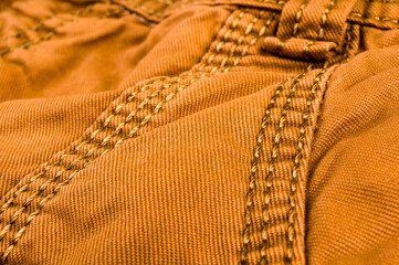 clothing items stonewashed cotton fabric texture with seams, clasps, buttons and rivets, macro