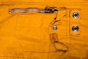 clothing items stonewashed cotton fabric texture with seams, clasps, buttons and rivets, macro