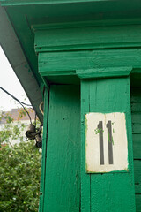 House number 11.An old sign on the wooden green facade of the house. Historic buildings.