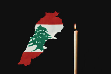 One light candle burning brightly and lebanon map with flag in the black background grunge sad style