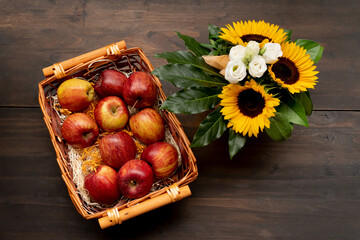 Sunflowers and apples on a wooden table. Summer background