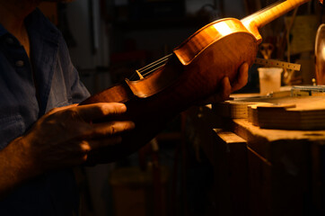 Luthier violin maker artisan setting up a violin in his workshop