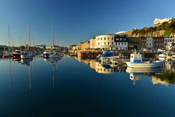 Fototapeta na wymiar English harbour, Jersey, U.K. Summer evening calm high tide at a 19th century commercial dock.