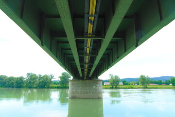 Green Metal structure of a bridge on a concrete pilar over a rriver