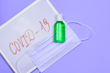 Covid 19 text on the whiteboard with antiseptic gel and face mask