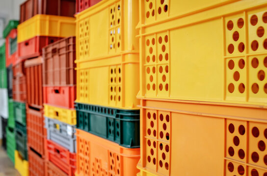 stack of colorful plastic crates or boxes for food products. Selective focus.